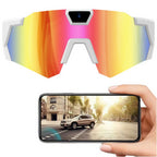 Colorful reflective sunglasses with a phone displaying a car on a road.