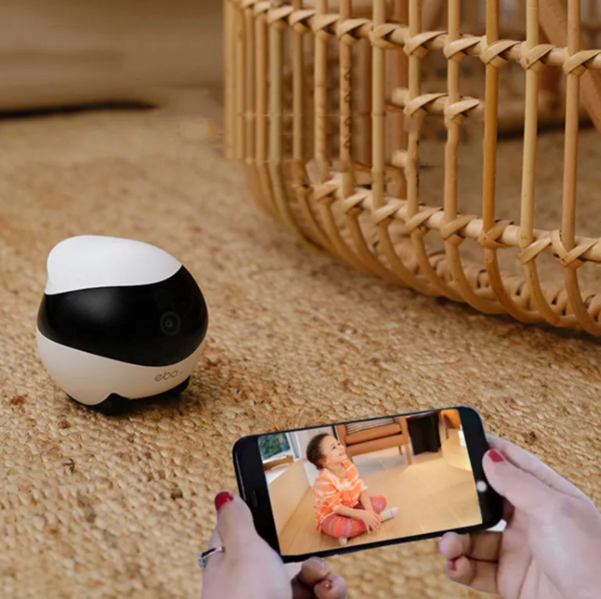 Smart home device on a carpet with a phone showing a video call to a child.